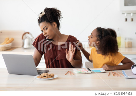 Angry teen girl sitting by working mom, kitchen interior 81984432