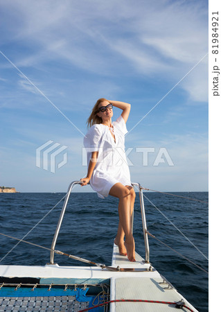 young woman drinking champagne on a yacht in the open sea young woman drinking champagne on a yacht in the open sea 81984921