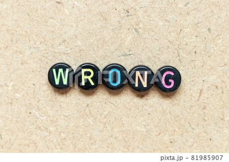 Black color round bead in word wrong on wood background Black color round bead in word wrong on wood background 81985907
