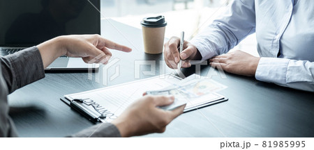 Man employee giving bribe money to business woman and pointing at the contract signing box 81985995