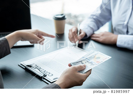 Man employee giving bribe money to business woman and pointing at the contract signing box 81985997