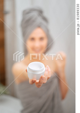 White jar with a cream for skin wrinkles in the hands of a girl blurred. White jar with a cream for skin wrinkles in the hands of a girl blurred. 81989330