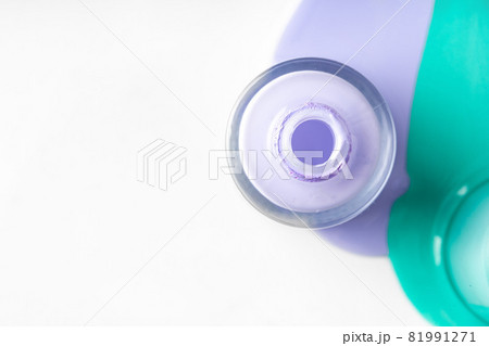 Pastel color spilled nail polish bottles over white 81991271