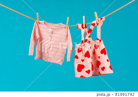 Clothesline with pinned baby clothes close up Clothesline with pinned baby clothes close up 81991792