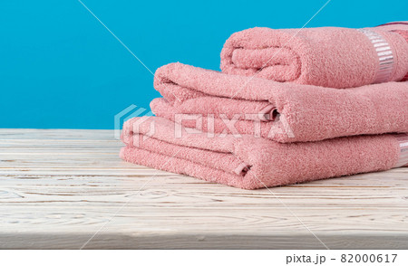 Stacked new towels on a wooden table Stacked new towels on a wooden table 82000617