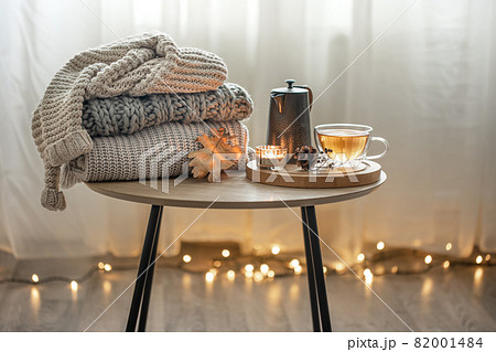 Cozy autumn composition with a cup of tea and a stack of knitted sweaters. Cozy autumn composition with a cup of tea and a stack of knitted sweaters. 82001484