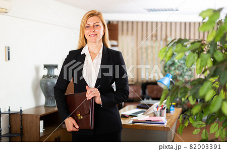Business woman posing in her office Business woman posing in her office 82003391