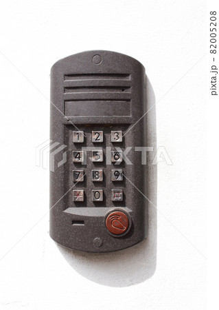 Gray metal intercom device on white concrete building wall with shadow Gray metal intercom device on white concrete building wall with shadow 82005208