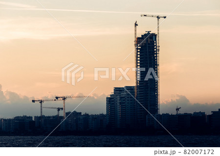 Silhouettes of unfinished high-rise buildings after sunset 82007172