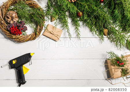 Make a Christmas wreath with your own hands. Spruce branch, Christmas wreath and gifts on a white wooden background 82008350