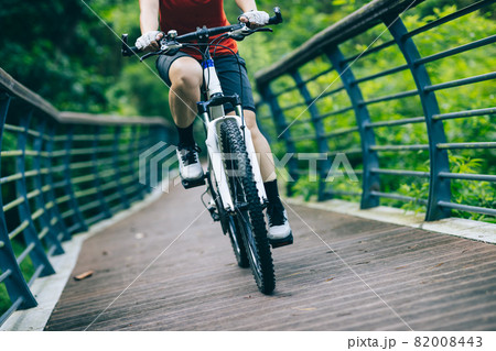 Woman riding bike in forest 82008443