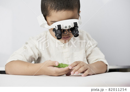 A little boy exploring slime structure with head magnifying glasses headset A little boy exploring slime structure with head magnifying glasses headset 82011254