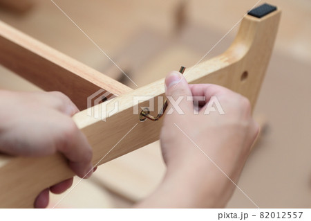 子供椅子を組み立てるパパの手元 82012557