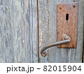 old rusted door handle on a wooden door 82015904