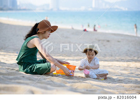 Mother and daughter picnic at the beach 82016004