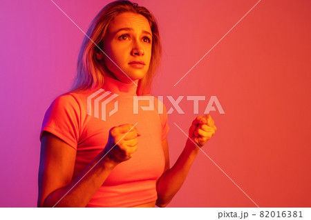 One caucasian girl with excitingly supporting facial expression isolated over gradient background in neon lights One caucasian girl with excitingly supporting facial expression isolated over gradient background in neon lights 82016381