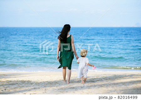 Mother and daughter having fun on the beach 82016499