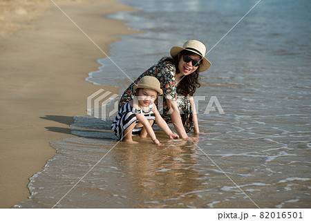 Mother and daughter having fun on the beach Mother and daughter having fun on the beach 82016501