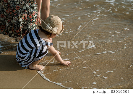 Mother and daughter having fun on the beach 82016502