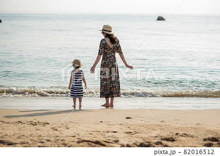 Mother and daughter having fun on the beach 82016512