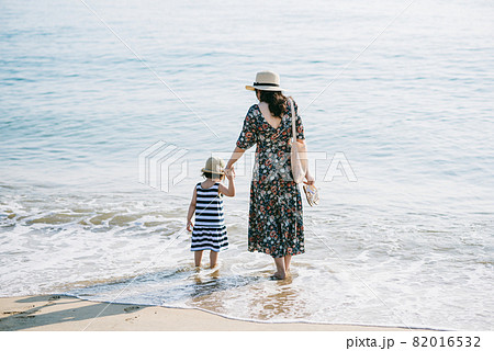 Mother and daughter having fun on the beach 82016532
