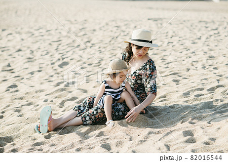 Mother and daughter having fun on the beach 82016544