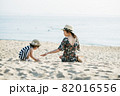 Mother and daughter having fun on the beach 82016556