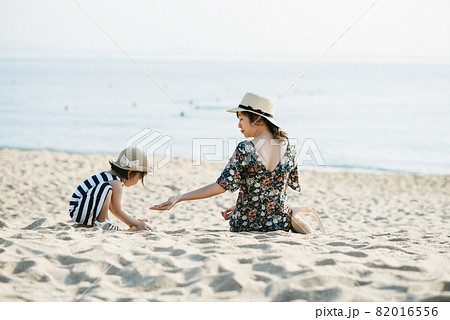 Mother and daughter having fun on the beach 82016556