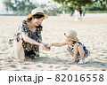 Mother and daughter having fun on the beach 82016558