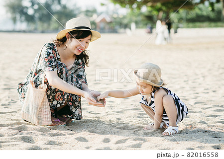Mother and daughter having fun on the beach Mother and daughter having fun on the beach 82016558