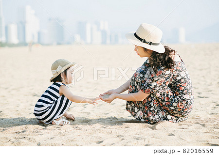 Mother and daughter having fun on the beach 82016559