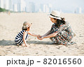 Mother and daughter having fun on the beach 82016560