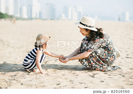 Mother and daughter having fun on the beach 82016560