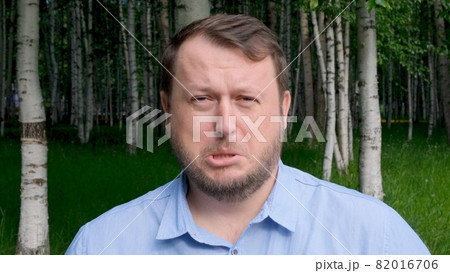 face of a distressed and sad man, 35 years old, dressed in a blue shirt on the street with emotions face of a distressed and sad man, 35 years old, dressed in a blue shirt on the street with emotions 82016706