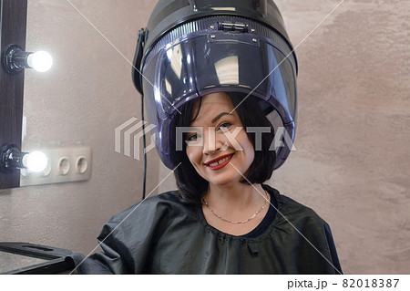 woman with black hair dries hair in hairdressing salon 82018387