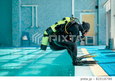 Male divers in scuba gear jump into the pool Male divers in scuba gear jump into the pool 82018786