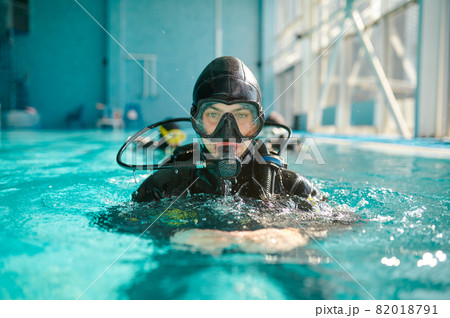 Male diver in scuba gear and mask poses in pool 82018791