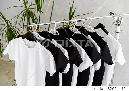 Row of black and white t-shirts hanging on rack 82021135