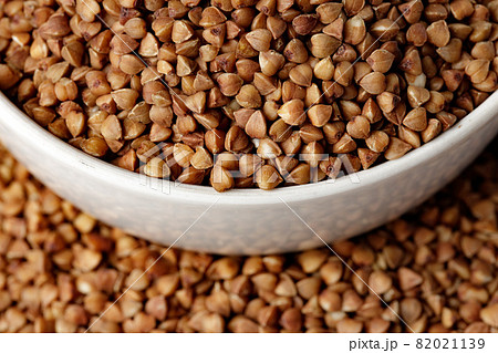 Bowl of raw uncooked buckwheat on wooden table 82021139