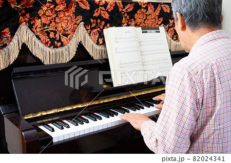 趣味でピアノを弾くシニア男性 82024341
