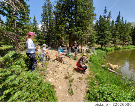 Hikers on shore of Hassell Lake in Arapaho National Forest, Colorado. 82026080