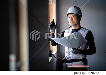図面を確認する作業員の男性 82026456
