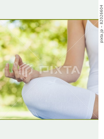 Mid section of a woman practicing yoga in the garden against white background 82026604