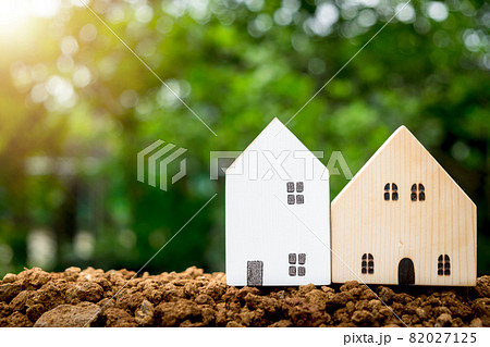 Miniature houses on soil with copyspace. Building blocks arranged in row. Miniature houses on soil with copyspace. Building blocks arranged in row. 82027125