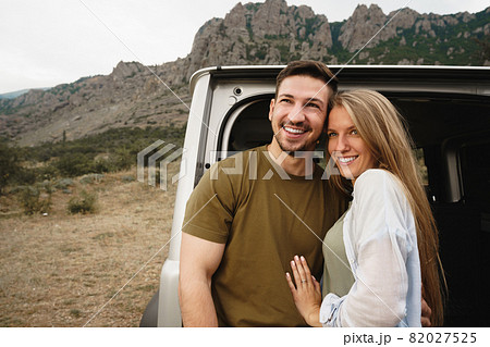 Young happy couple on a road trip sitting in car trunk 82027525