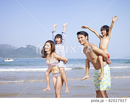 asian family with two children having fun on beach asian family with two children having fun on beach 82027927