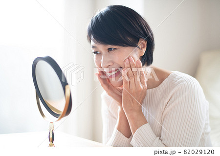 鏡でスキンケアをする上品なミセス女性 鏡でスキンケアをする上品なミセス女性 82029120
