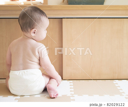 お座りをして裸でおむつをしている赤ちゃんの後ろ姿 82029122