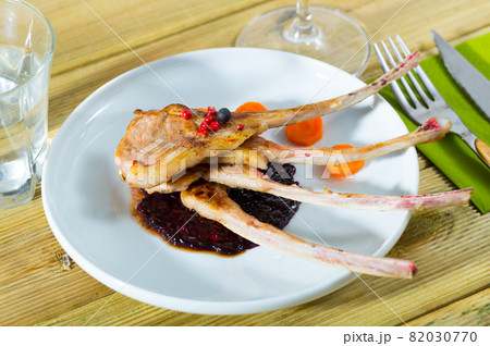 Baked under tasty lamb ribs served with sauce and carrots Baked under tasty lamb ribs served with sauce and carrots 82030770