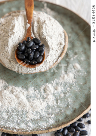 Ceramic bowls with black beans flour with a wooden spoon Ceramic bowls with black beans flour with a wooden spoon 82034456